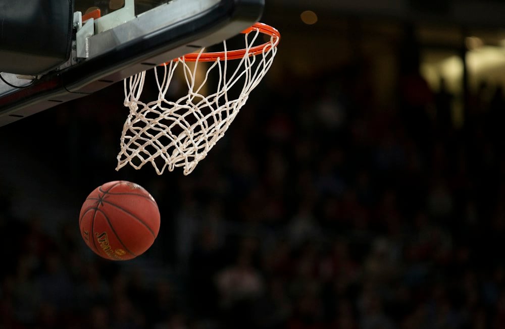 A basketball hoop and ball during a sporting event.